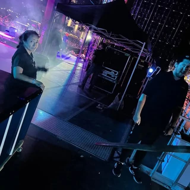 Experienced stage techs configuring sound and visual monitors backstage