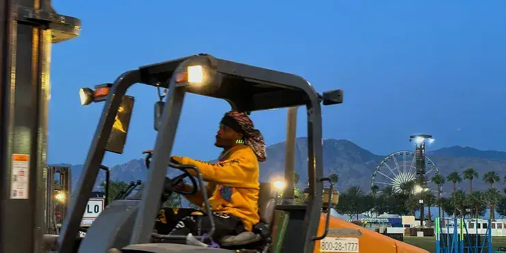Forklift operator and logistics worker moving inventory in a warehouse
